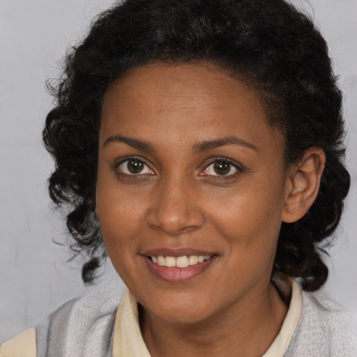 Joyful black young-adult female with medium  brown hair and brown eyes