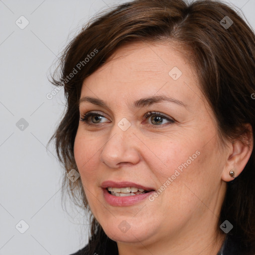 Joyful white adult female with medium  brown hair and brown eyes