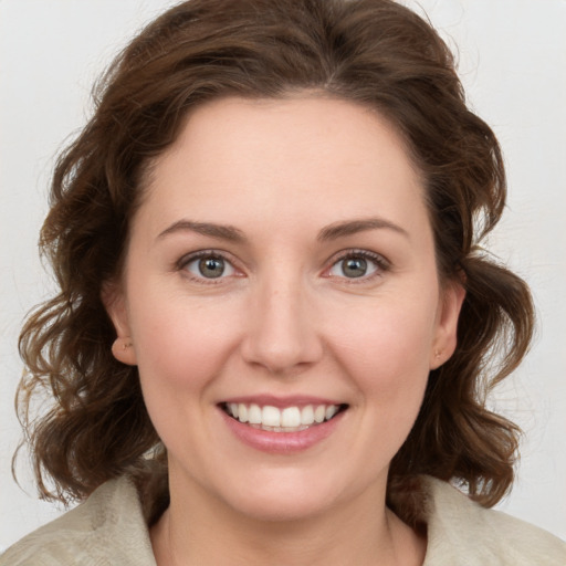 Joyful white young-adult female with medium  brown hair and green eyes