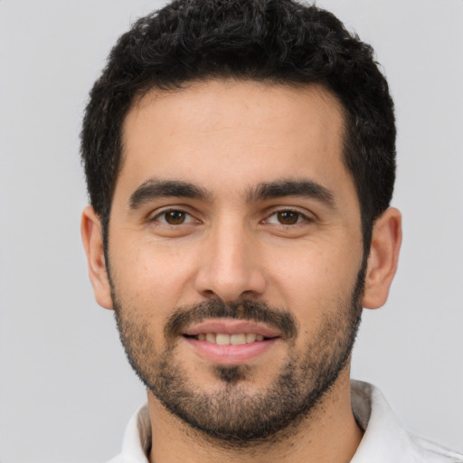 Joyful white young-adult male with short  black hair and brown eyes