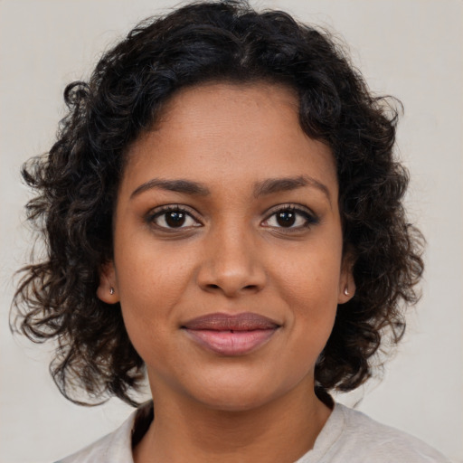 Joyful black young-adult female with medium  brown hair and brown eyes