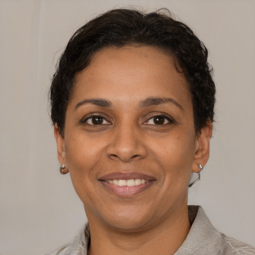 Joyful latino adult female with short  brown hair and brown eyes