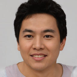 Joyful asian young-adult male with short  black hair and brown eyes
