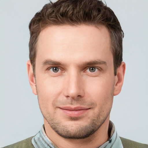 Joyful white young-adult male with short  brown hair and grey eyes