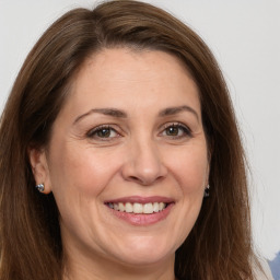 Joyful white adult female with long  brown hair and brown eyes