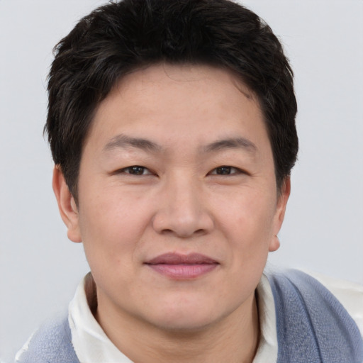 Joyful asian adult male with short  brown hair and brown eyes