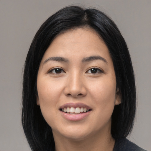 Joyful asian young-adult female with long  black hair and brown eyes