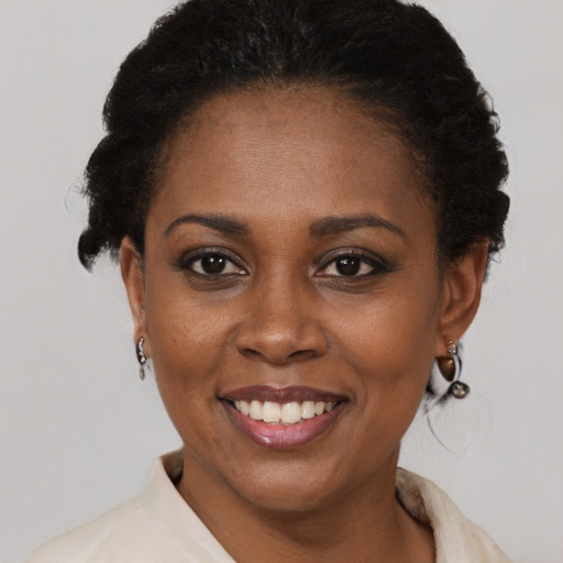 Joyful black adult female with short  black hair and brown eyes