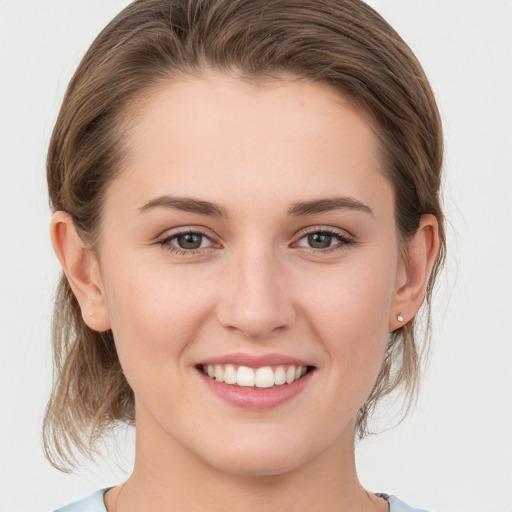 Joyful white young-adult female with medium  brown hair and grey eyes