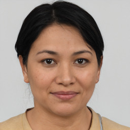 Joyful latino young-adult female with short  brown hair and brown eyes