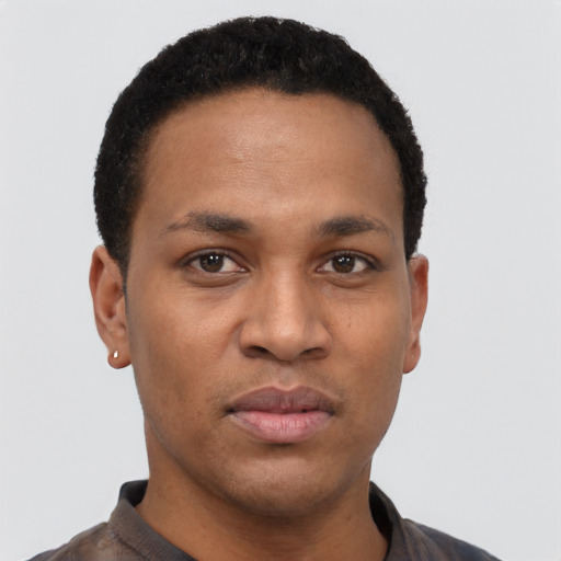 Joyful black young-adult male with short  black hair and brown eyes