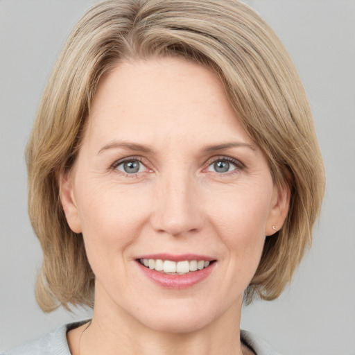 Joyful white adult female with medium  brown hair and grey eyes