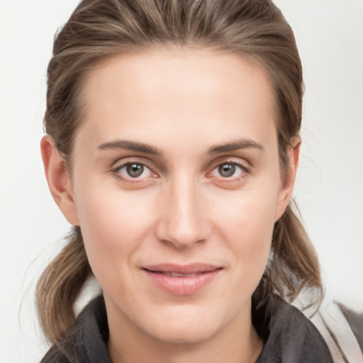 Joyful white young-adult female with medium  brown hair and grey eyes