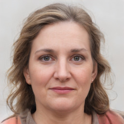 Joyful white adult female with medium  brown hair and grey eyes