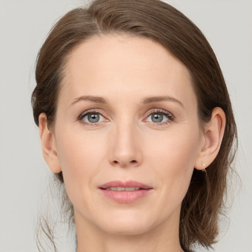 Joyful white young-adult female with medium  brown hair and grey eyes