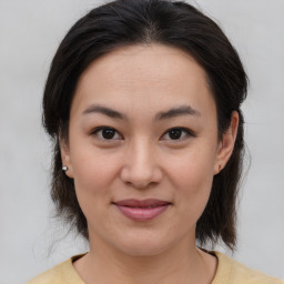 Joyful asian young-adult female with medium  brown hair and brown eyes