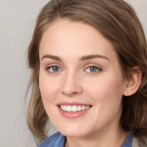 Joyful white young-adult female with medium  brown hair and blue eyes