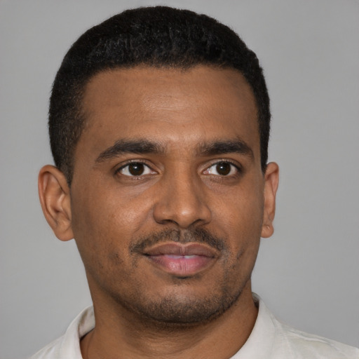 Joyful black young-adult male with short  black hair and brown eyes