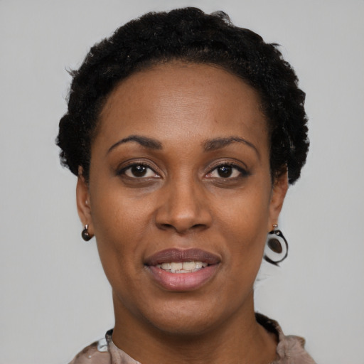 Joyful black young-adult female with short  black hair and brown eyes