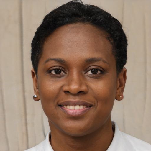 Joyful black young-adult female with short  brown hair and brown eyes