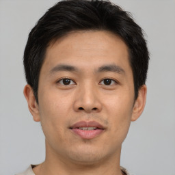 Joyful asian young-adult male with short  brown hair and brown eyes