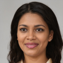 Joyful black young-adult female with long  brown hair and brown eyes