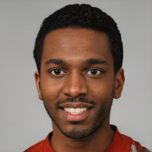 Joyful black young-adult male with short  black hair and brown eyes