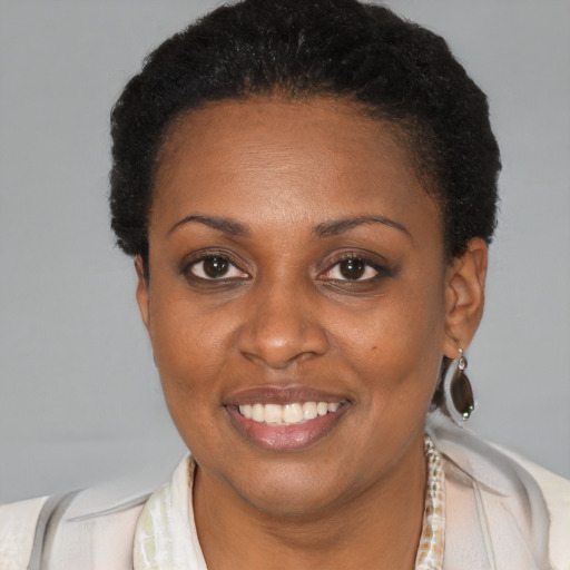 Joyful black young-adult female with short  brown hair and brown eyes