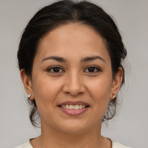 Joyful latino young-adult female with medium  brown hair and brown eyes