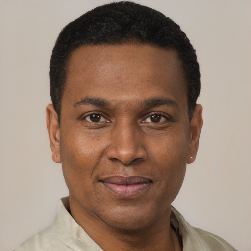 Joyful black young-adult male with short  black hair and brown eyes