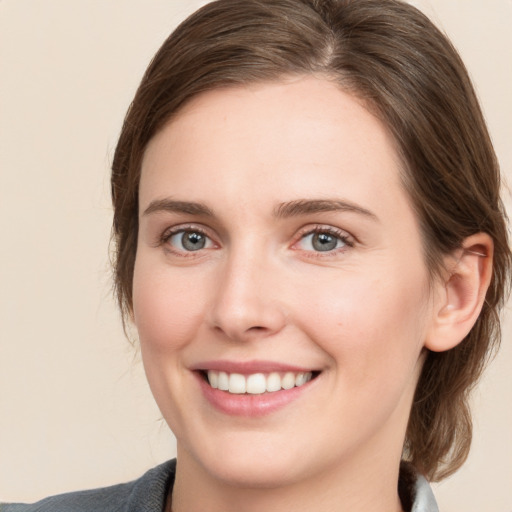 Joyful white young-adult female with medium  brown hair and blue eyes