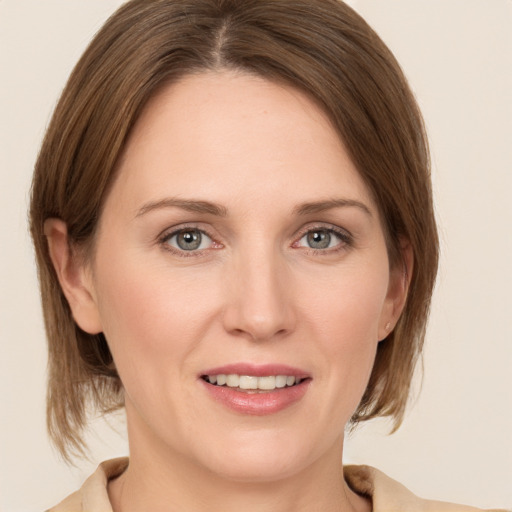 Joyful white young-adult female with medium  brown hair and grey eyes