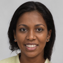 Joyful black young-adult female with long  brown hair and brown eyes