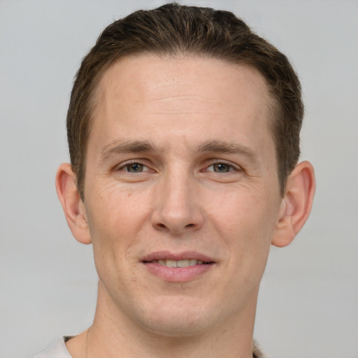 Joyful white adult male with short  brown hair and grey eyes