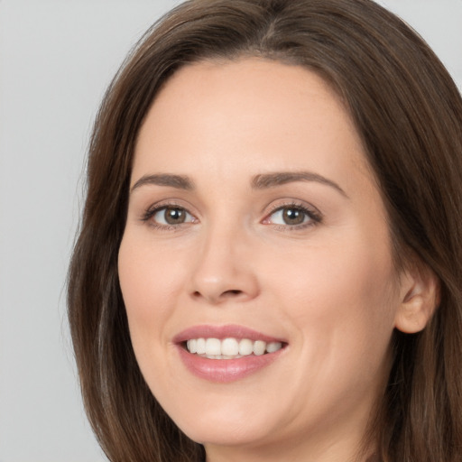 Joyful white young-adult female with long  brown hair and brown eyes