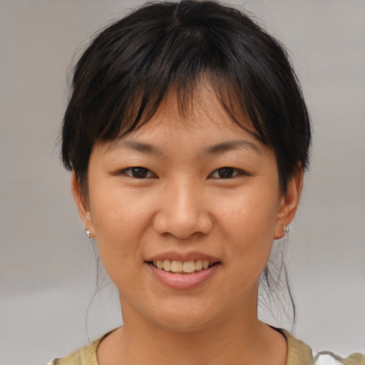 Joyful asian young-adult female with medium  brown hair and brown eyes