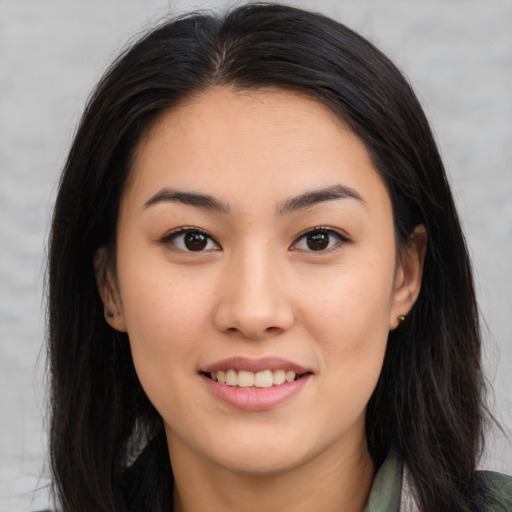 Joyful asian young-adult female with long  brown hair and brown eyes