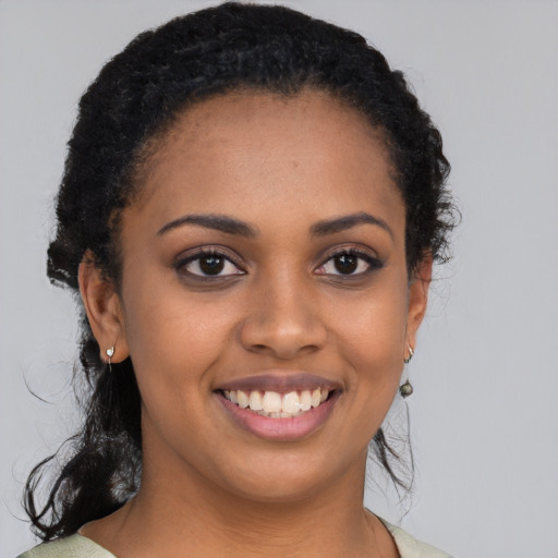 Joyful black young-adult female with medium  black hair and brown eyes