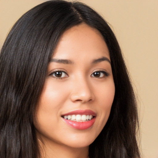 Joyful latino young-adult female with long  brown hair and brown eyes