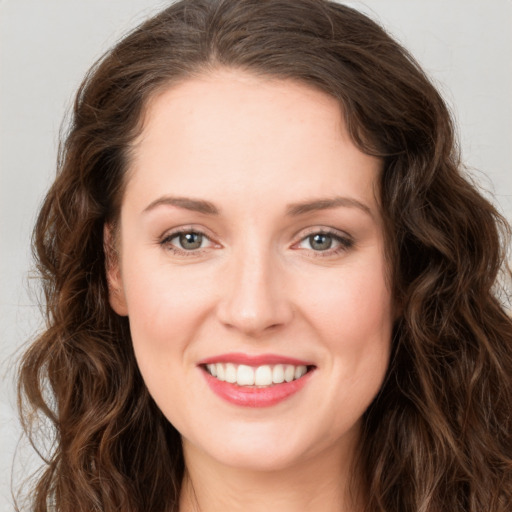 Joyful white young-adult female with long  brown hair and green eyes