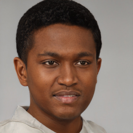 Joyful black young-adult male with short  brown hair and brown eyes