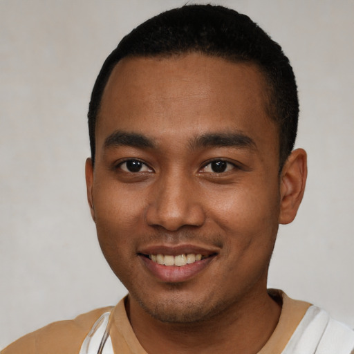 Joyful black young-adult male with short  black hair and brown eyes