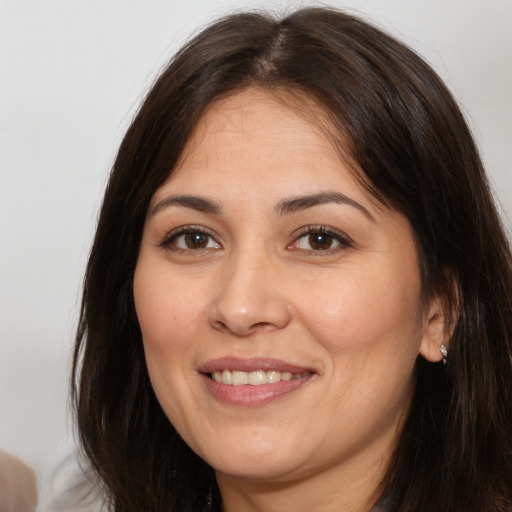 Joyful white adult female with long  brown hair and brown eyes