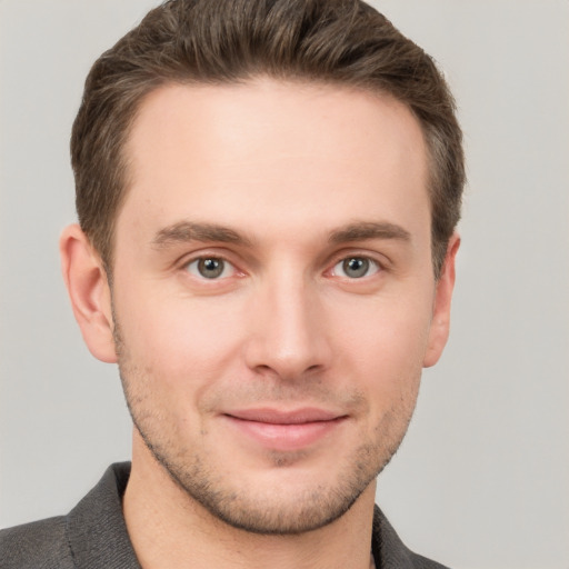 Joyful white young-adult male with short  brown hair and grey eyes