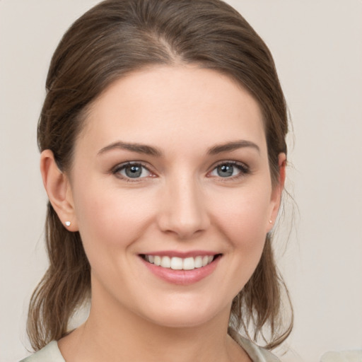 Joyful white young-adult female with medium  brown hair and grey eyes