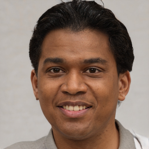 Joyful latino adult male with short  brown hair and brown eyes