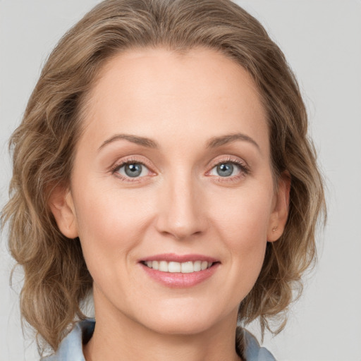 Joyful white young-adult female with medium  brown hair and blue eyes