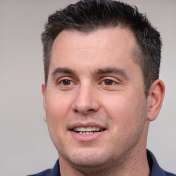 Joyful white adult male with short  brown hair and brown eyes