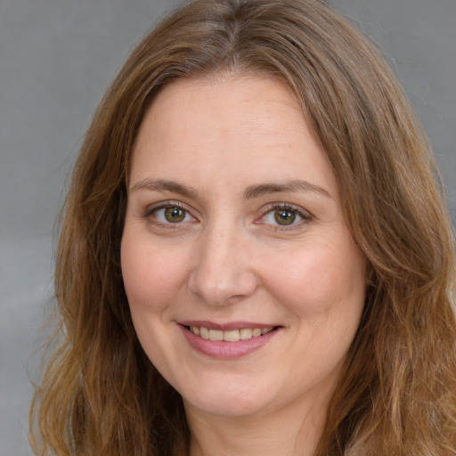 Joyful white adult female with long  brown hair and green eyes