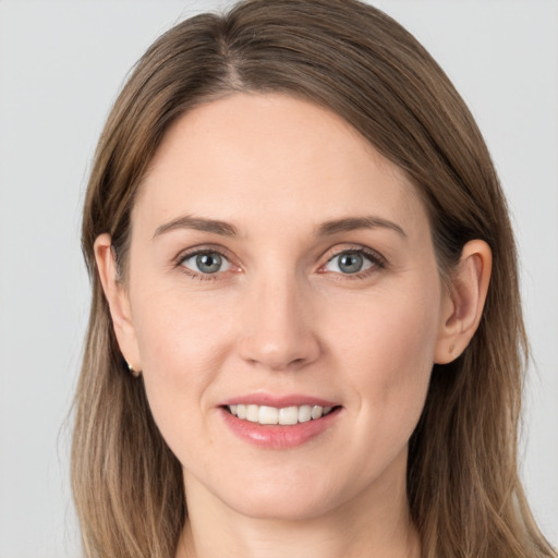 Joyful white young-adult female with long  brown hair and grey eyes